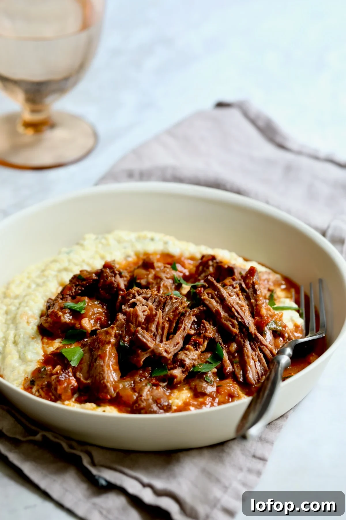 Authentic Stracotto: Italian Pot Roast Recipe for Slow-Cooked Beef 10 One serving of Italian Pot Roast (Stracotto) in white dinner bowl with fork.
