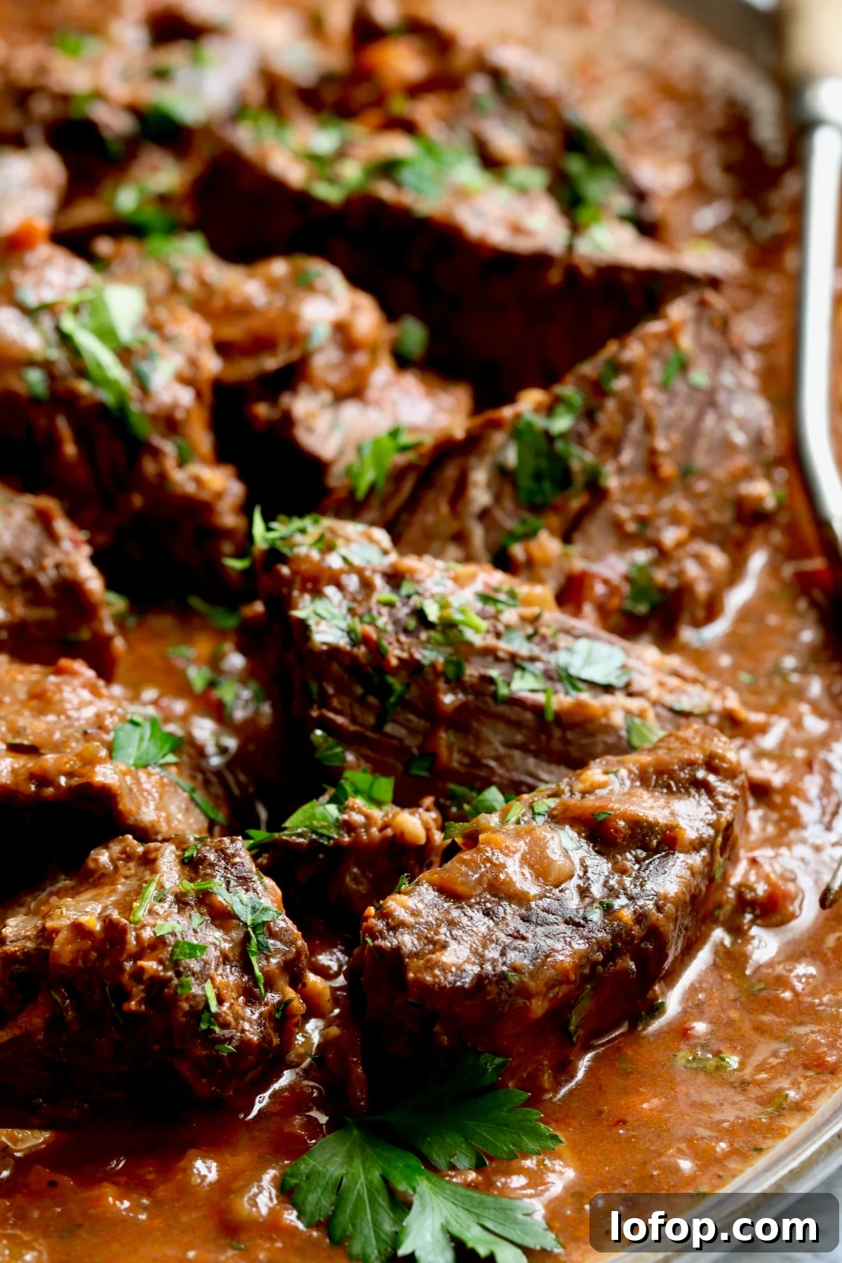 Authentic Stracotto: Italian Pot Roast Recipe for Slow-Cooked Beef 3 Italian Pot Roast (Stracotto) on platter with serving fork.