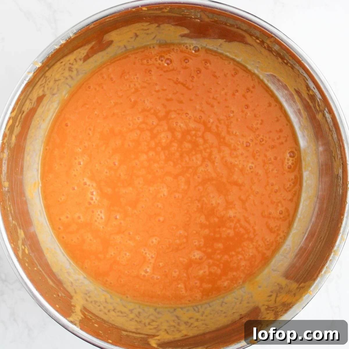Pumpkin, eggs, oil and sugar blended in a bowl.