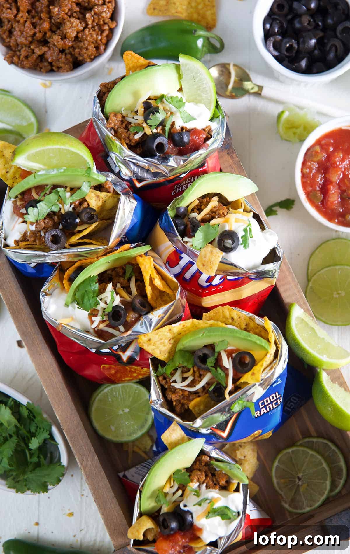 Walking Tacos: Easy Portable Taco Cups for Parties and Picnics 2 Several chip bags are filled with taco ingredients.