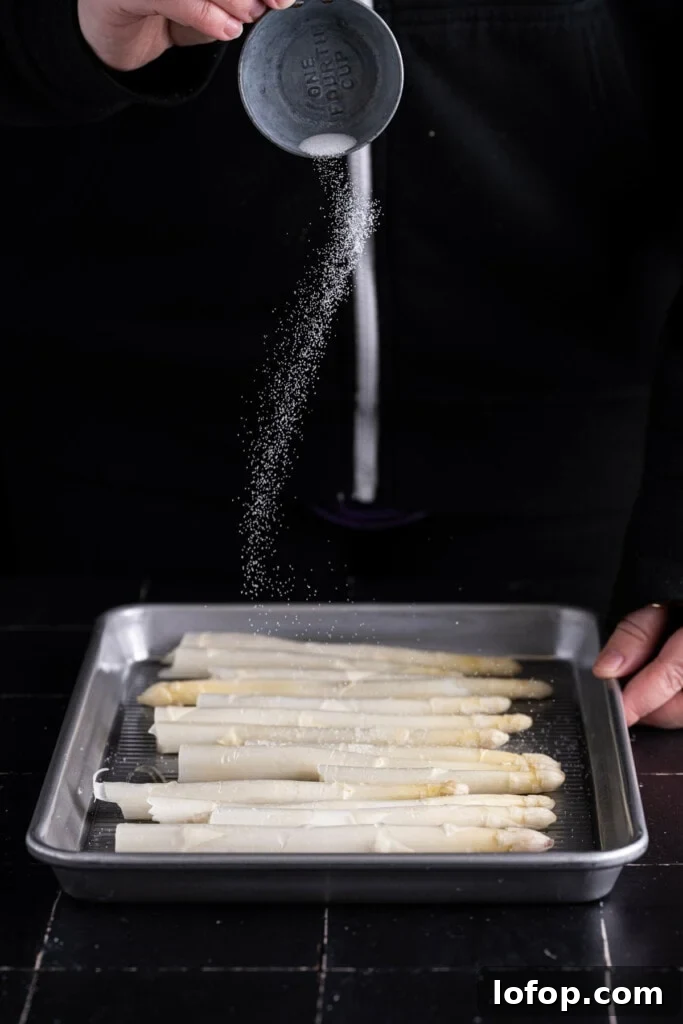Adding salt before roasting white asparagus.