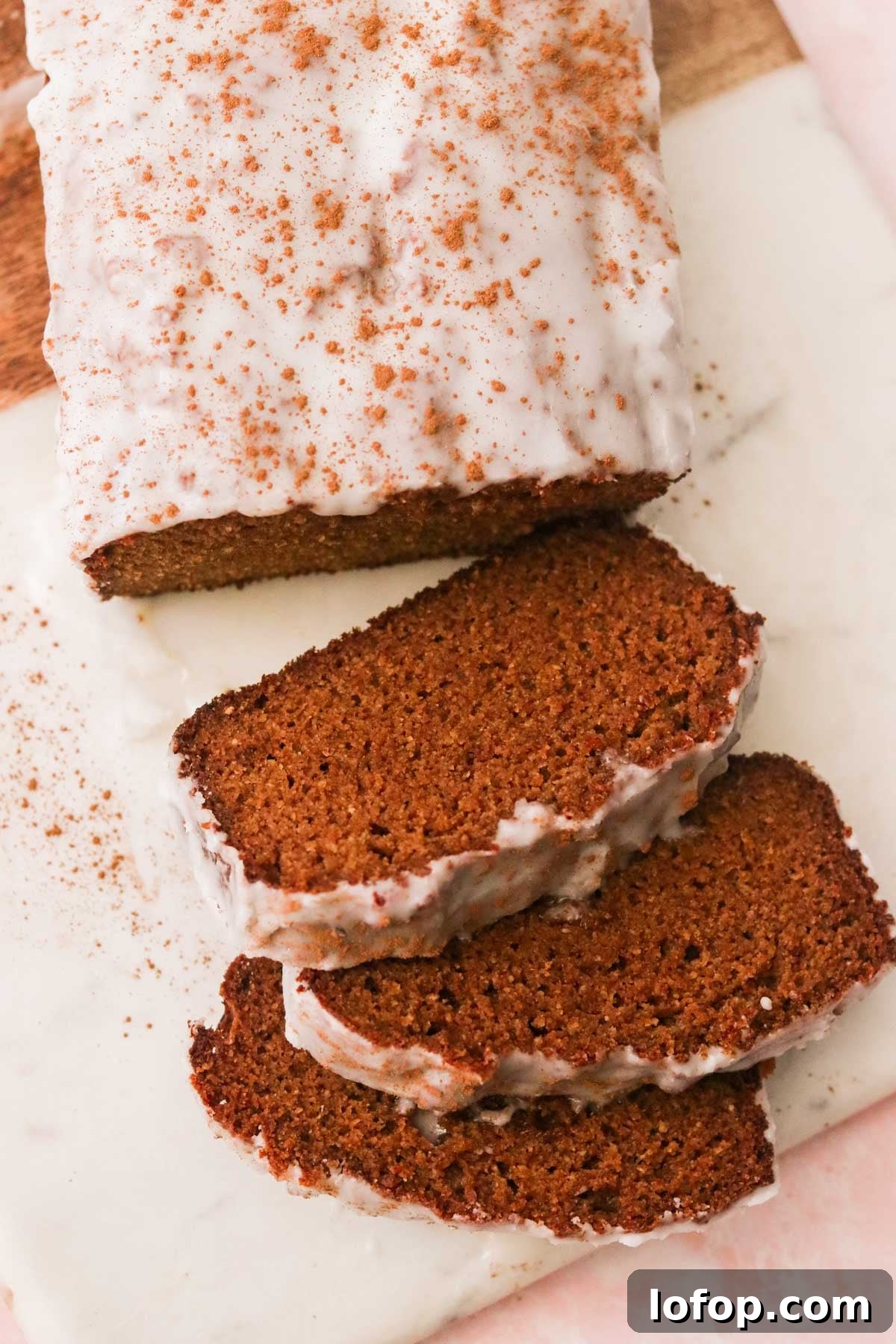 a gluten free gingerbread loaf topped with a sugar glaze and sprinkled with cinnamon