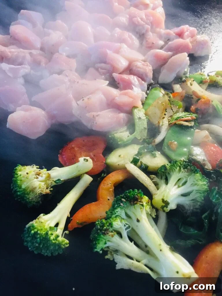 adding chicken to the griddle