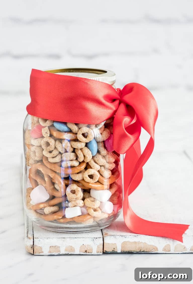 a jar of sweet and salty snack mix with a ribbon
