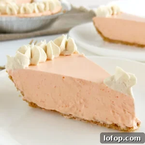 slice of Jello orange creamsicle pie topped with whipped cream on a plate