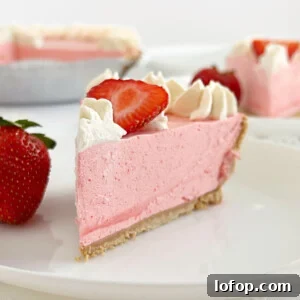 slice of no bake strawberry jello pie with cool whip, fresh strawberries and whipped cream