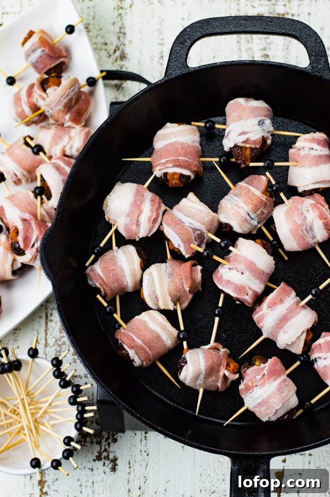 Bacon-Wrapped Stuffed Dates with Goat Cheese and Almonds 5 A black cast iron skillet holds bacon wrapped dates, uncooked.