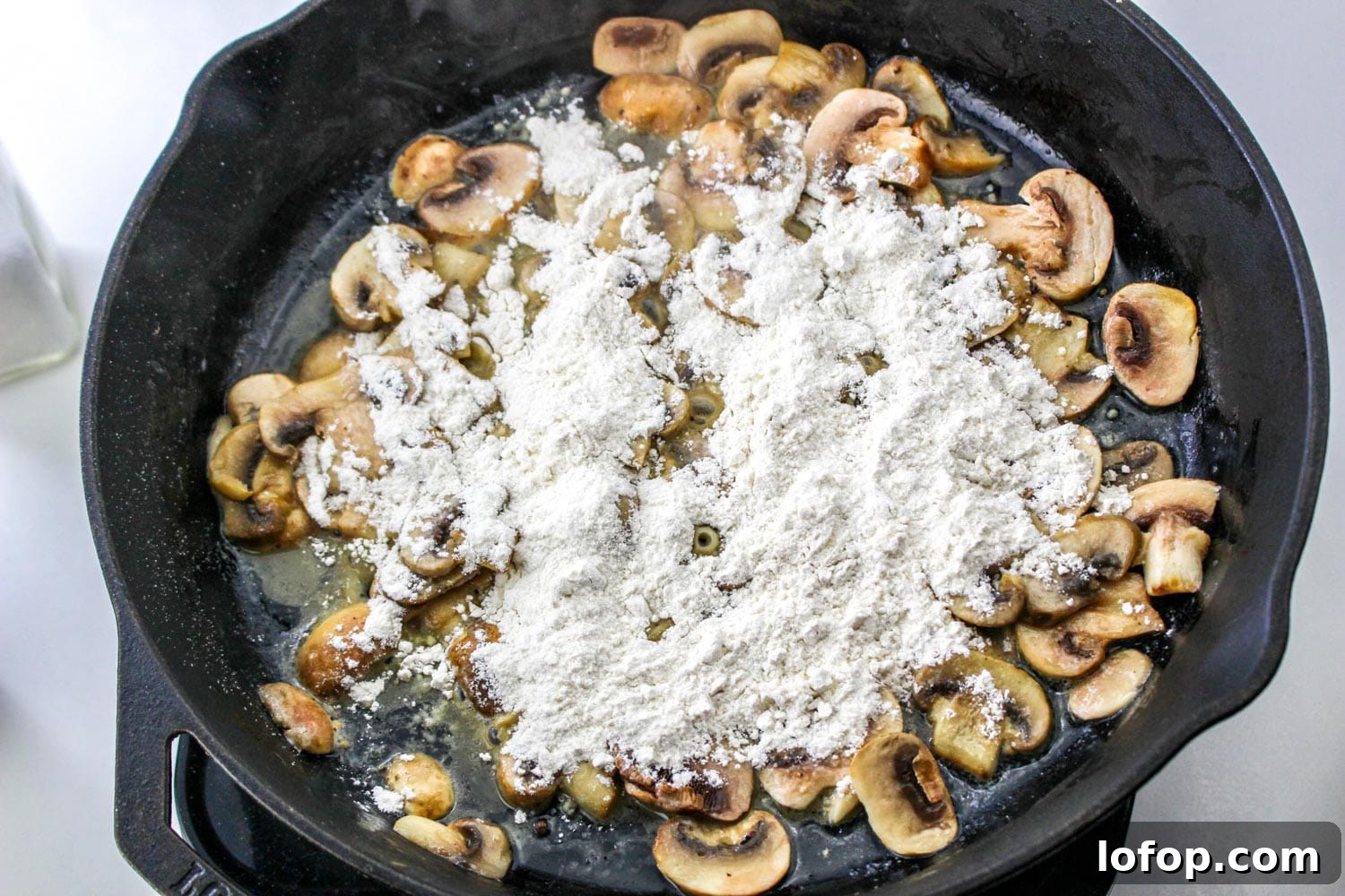 Savory Mushroom Meatloaf with Rich Mushroom Gravy 7 Sauteed mushrooms in a cast iron pan, with flour sprinkled all over them