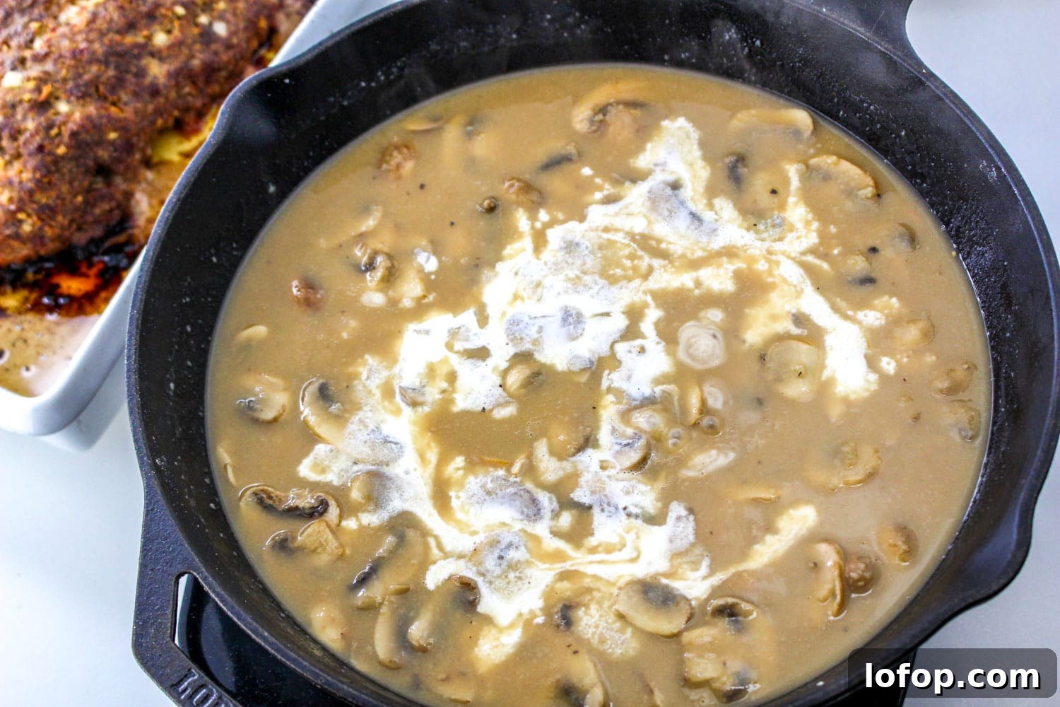 Savory Mushroom Meatloaf with Rich Mushroom Gravy 8 Mushroom sauce in a pan with cream added