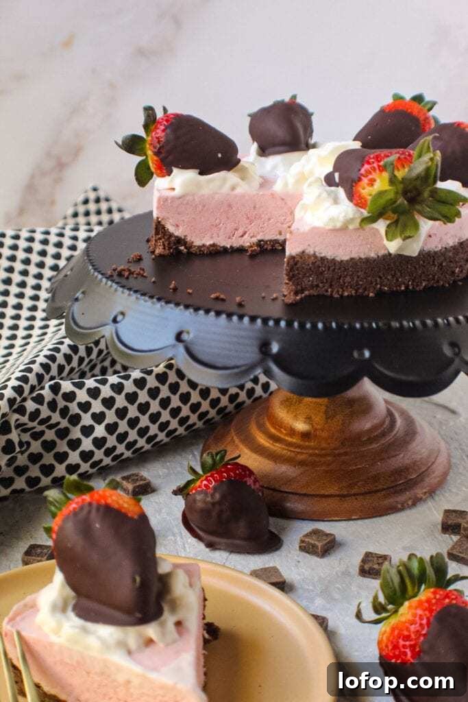 No-Bake Chocolate Strawberry Cheesecake Recipe for Summer 6 chocolate strawberry no-bake cheesecake on cake stand topped with whipped cream and strawberries