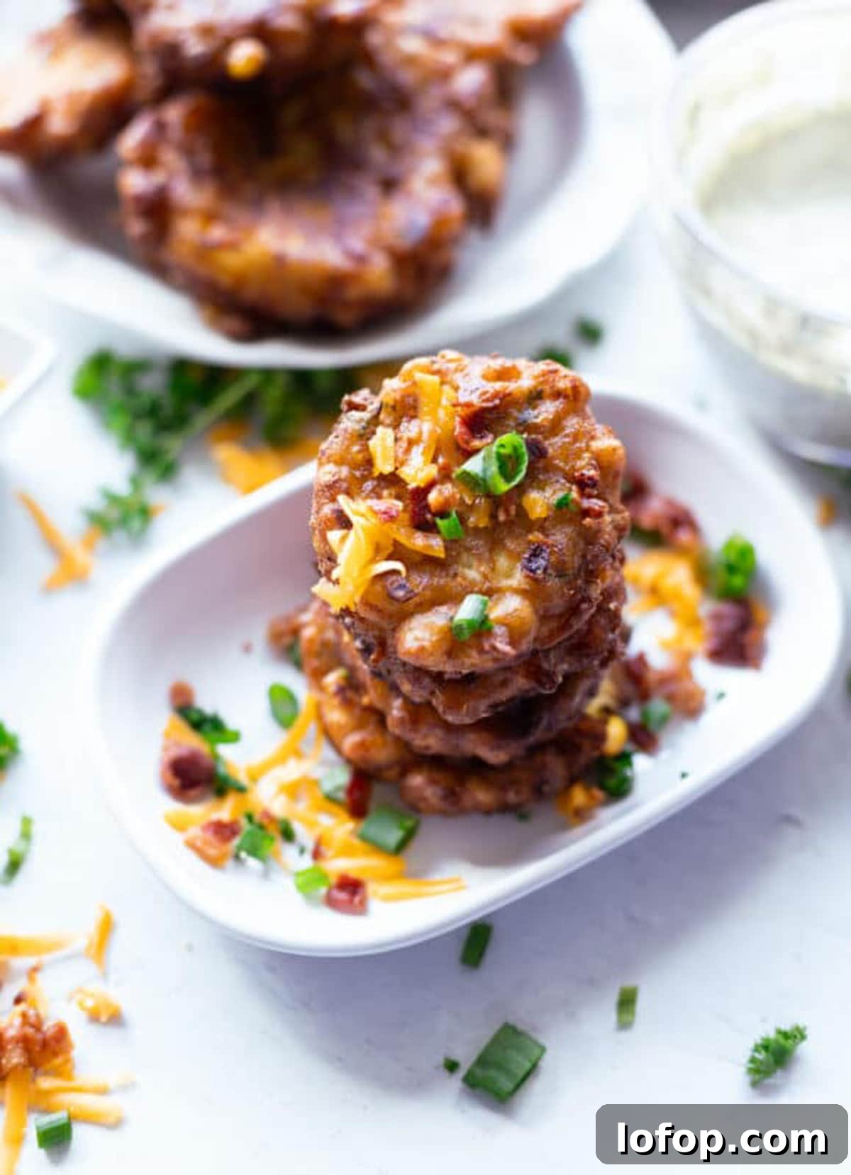 Stacked corn fritter in a white dish. 