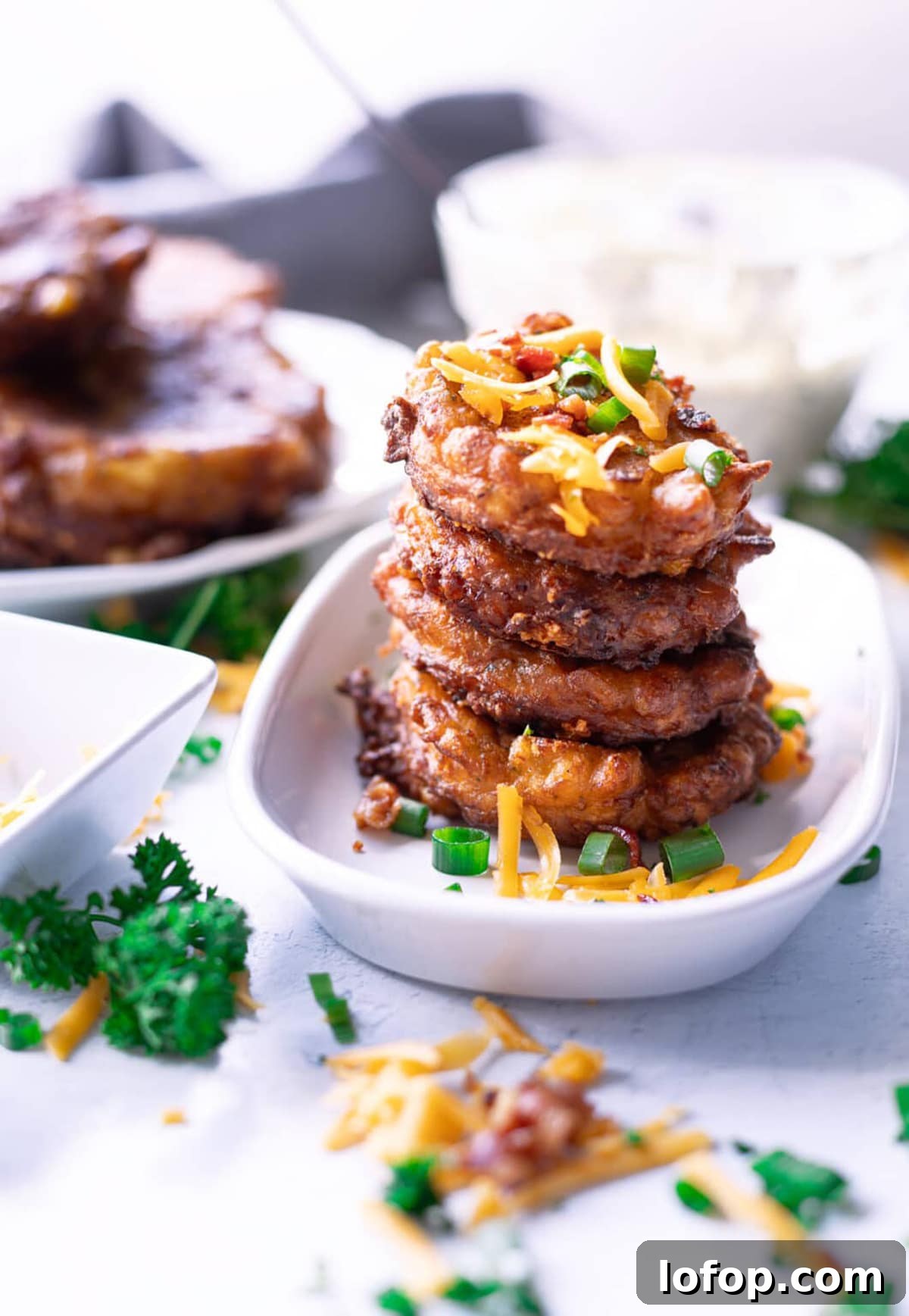 Stacked corn fritters in a white dish. 