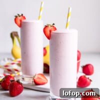 two pink smoothies with strawberries and bananas.