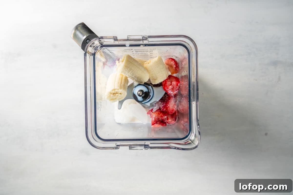 bananas, strawberries, milk, and ice in a blender.