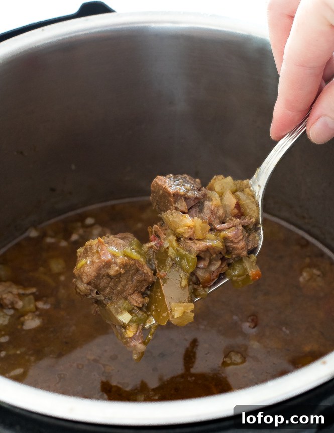 scooping shredded Barbacoa beef out of the Instant Pot