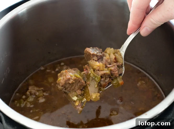 scooping out shredded beef from pressure cooker
