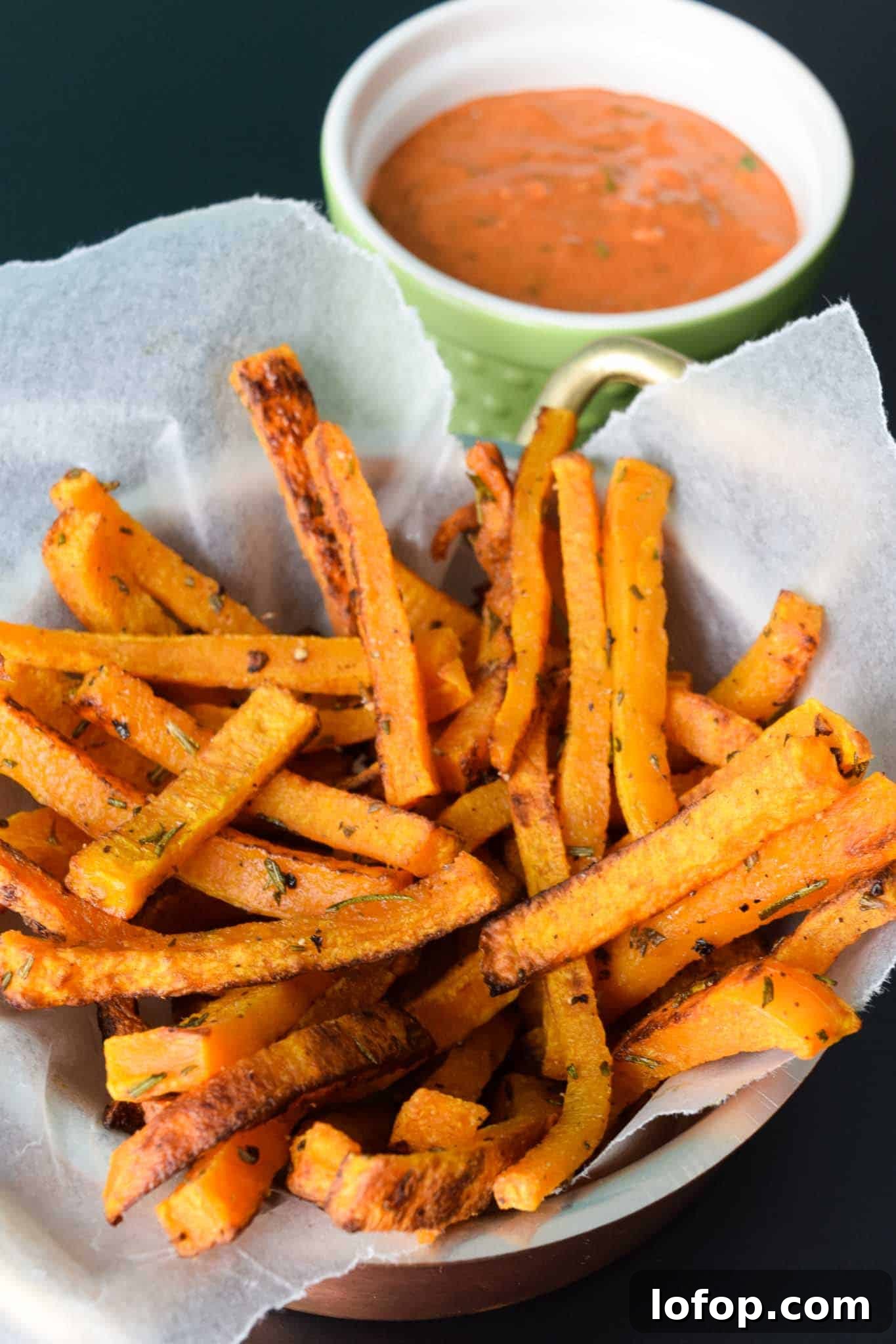 Crispy Butternut Squash Fries with Savory Magic Sauce 3 Butternut Squash Fries in waxed paper lined bowl with magic sauce in green bowl behind
