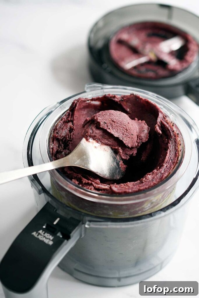 Vegan Blueberry Matcha Ice Cream Recipe (Ninja Creami, Dates & Oats) 2 Vegan blueberry matcha ice cream in a Ninja Creami pint inside of the outer bowl.