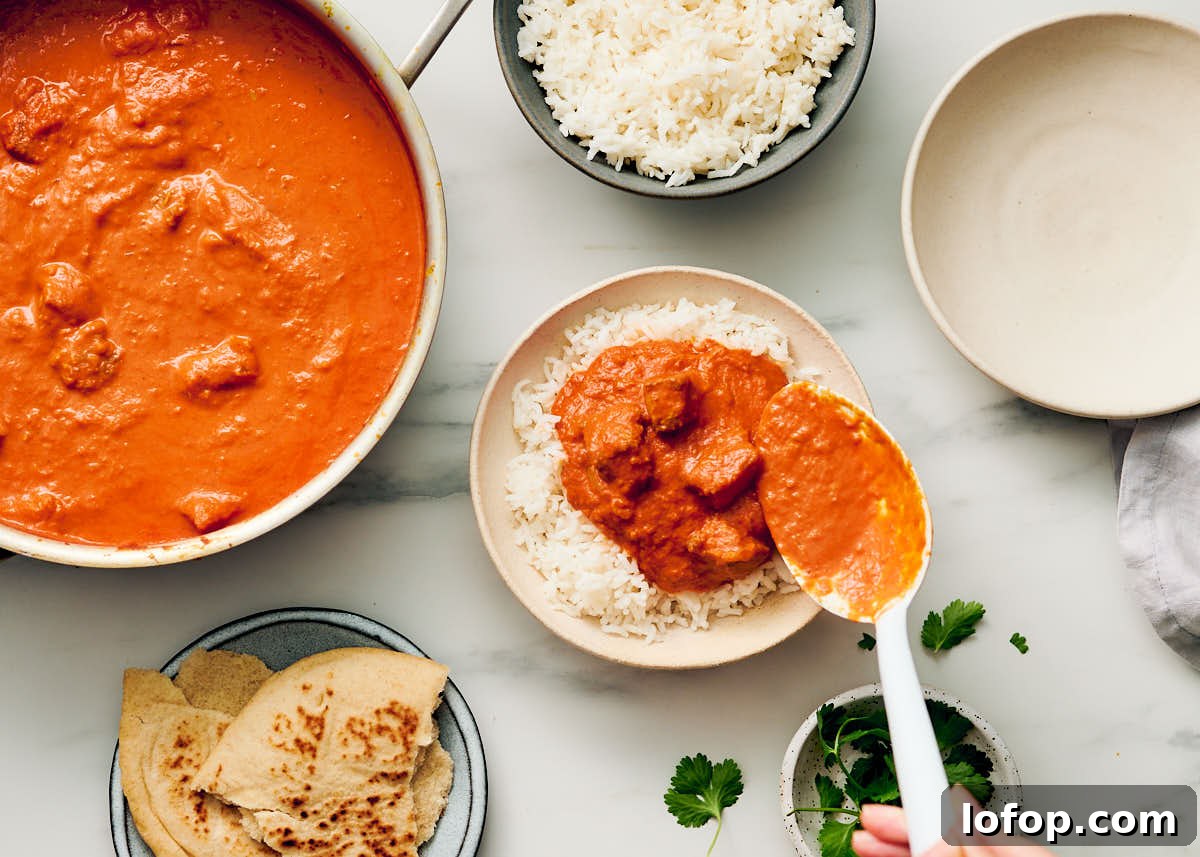 Vegetarian butter chicken being spooned over a bowl of rice.