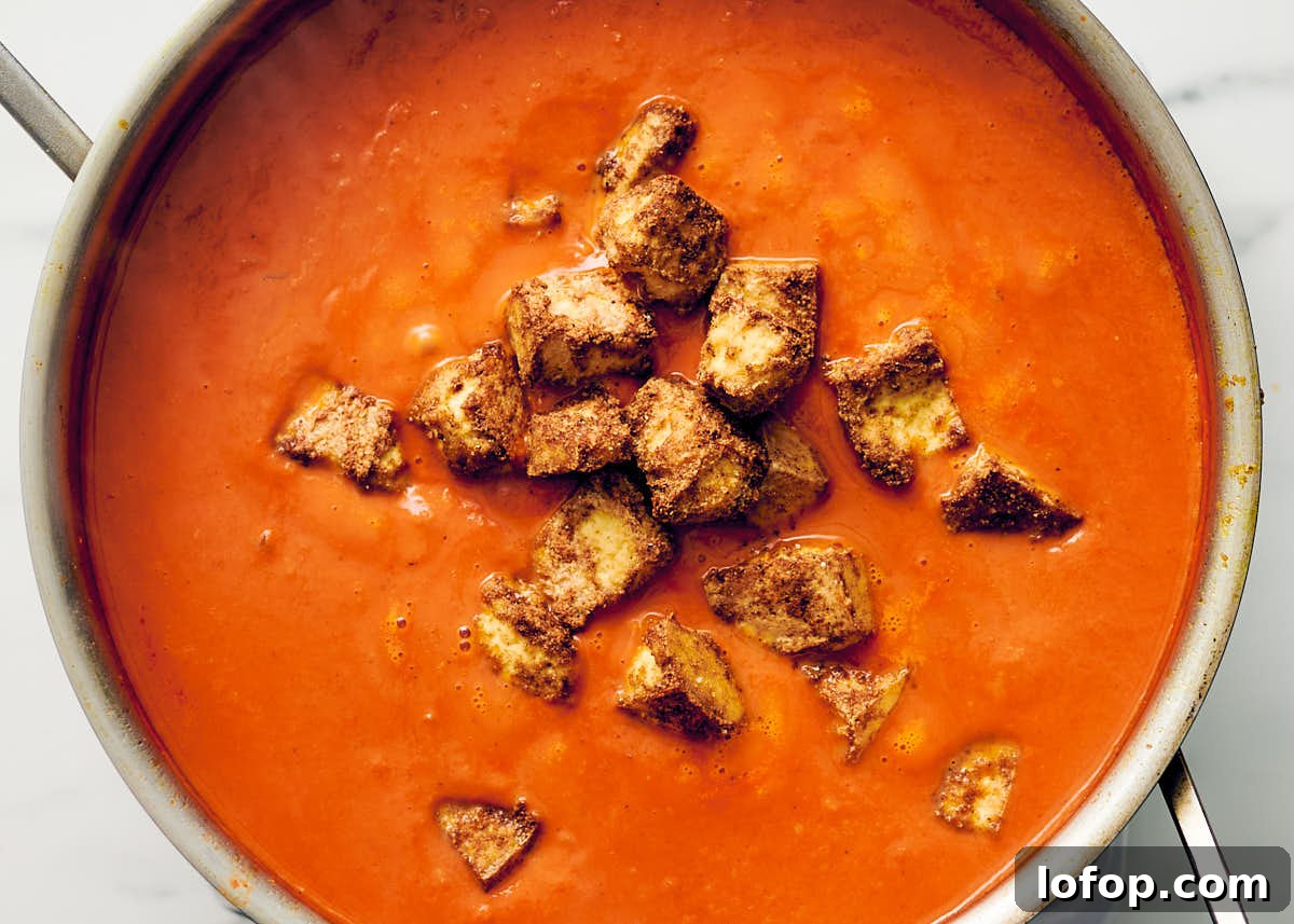 Veggie butter chicken sauce in a pan with oven baked tofu.