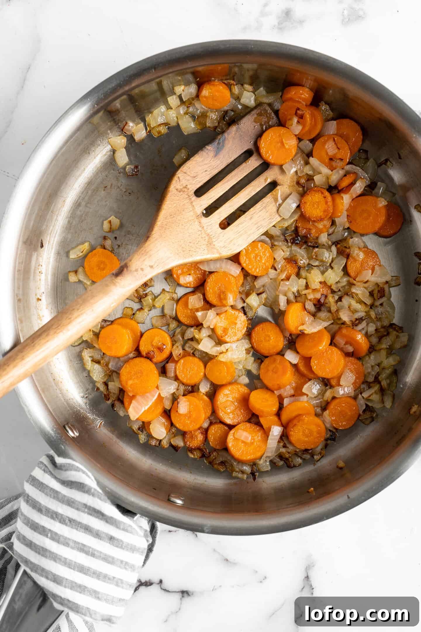 Sauteing carrots, onions, and garlic to make vegan queso