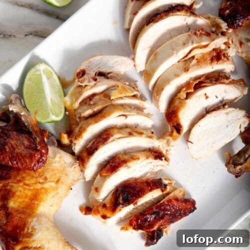 sliced beer can chicken on a white plate