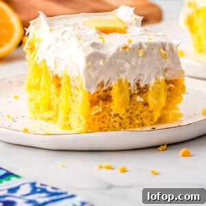 A slice of lemon poke cake on a white plate.