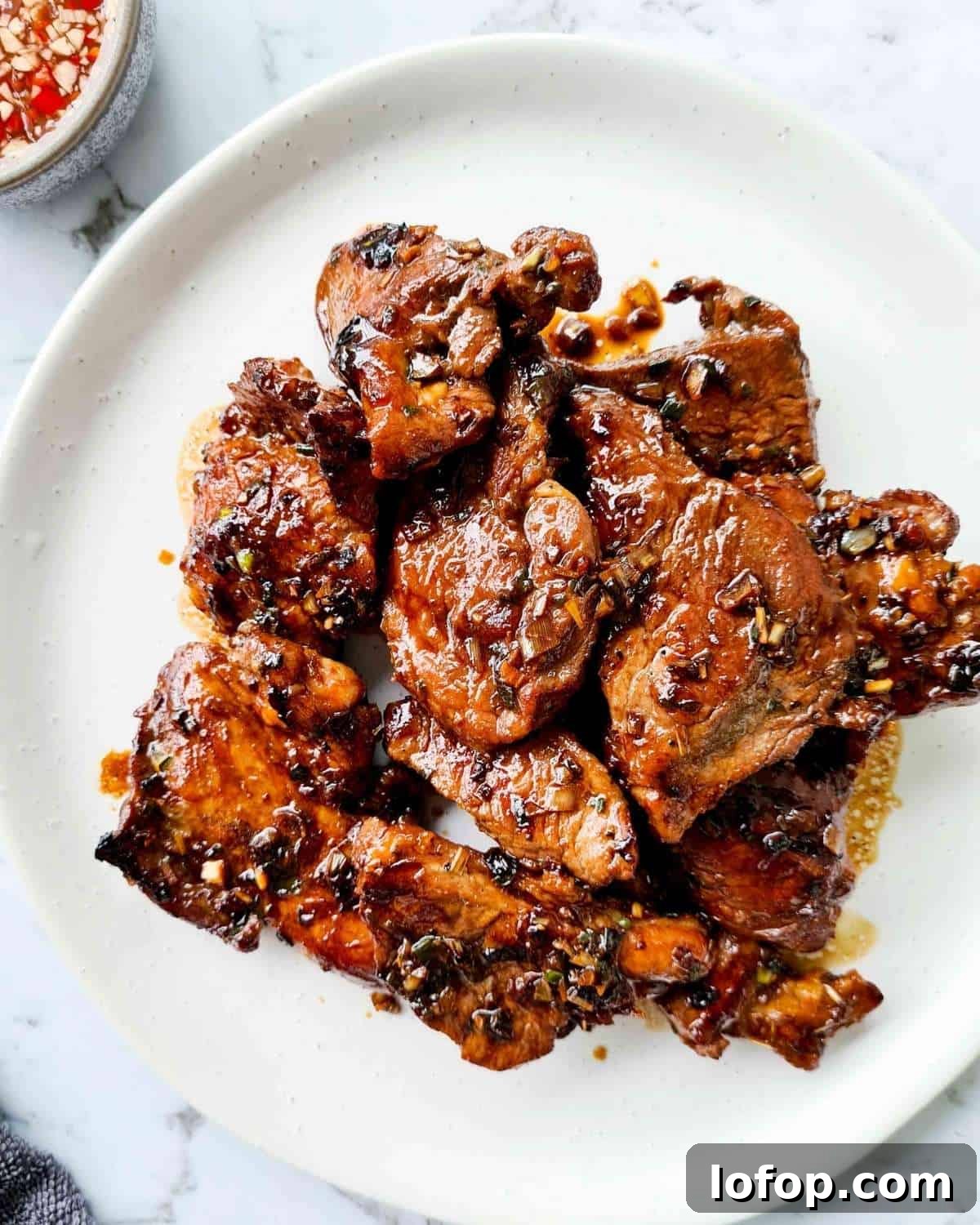 A large plate of caramelised pork chops on a white plate