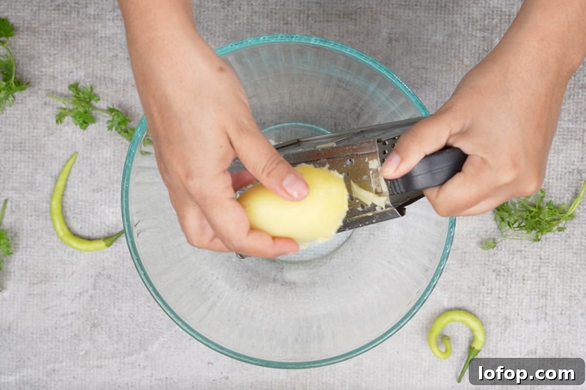 Grating the potato in a bowl.