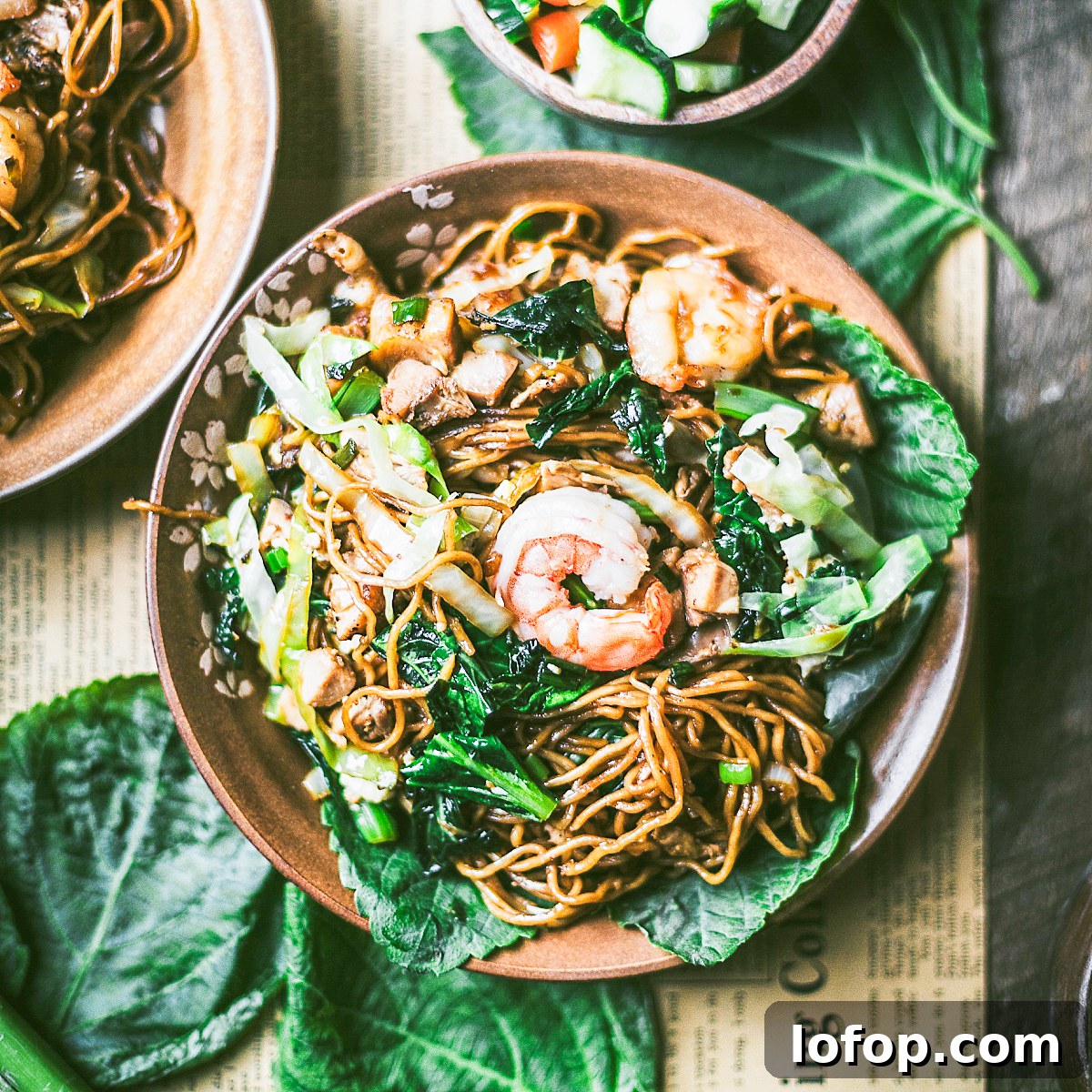 succulent shrimp topping a plate of Indonesian chicken mie goreng featuring asian greens