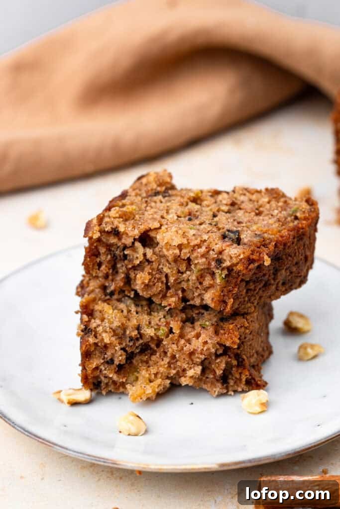 Ultra-Moist Gluten-Free Zucchini Bread with a Secret Ingredient 3 side view of slices of Extra Moist Gluten Free Zucchini Bread on a plate stacked on top of each other