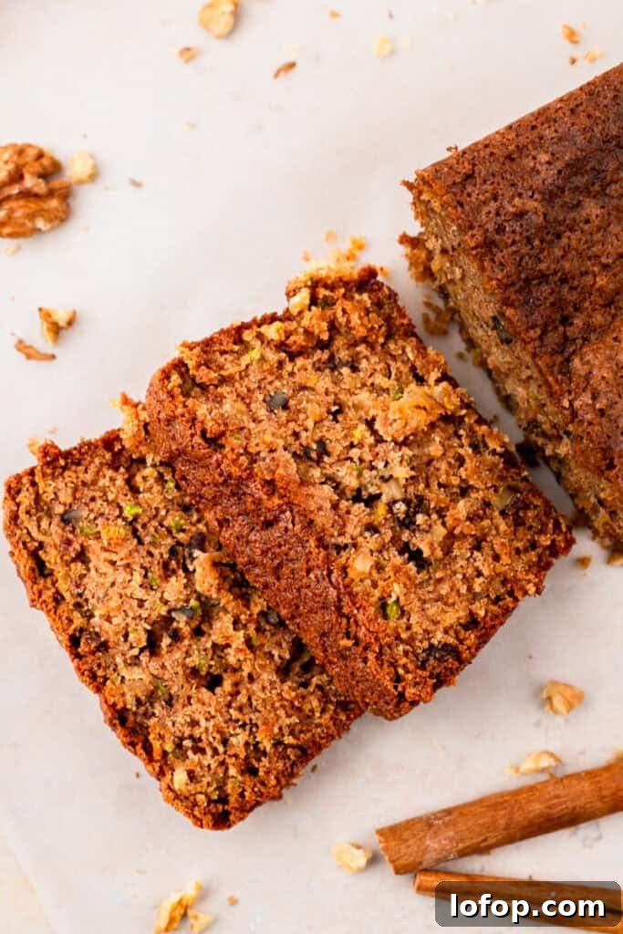 Ultra-Moist Gluten-Free Zucchini Bread with a Secret Ingredient 8 top down image of Extra Moist Gluten Free Zucchini Bread with slices of bread cut off of the loaf sitting on a counter with crumbs