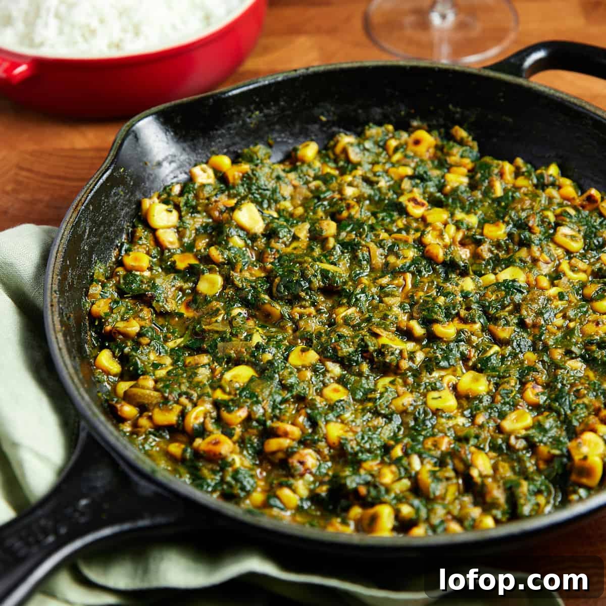 Photo of vegan palak corn in a black pan.
