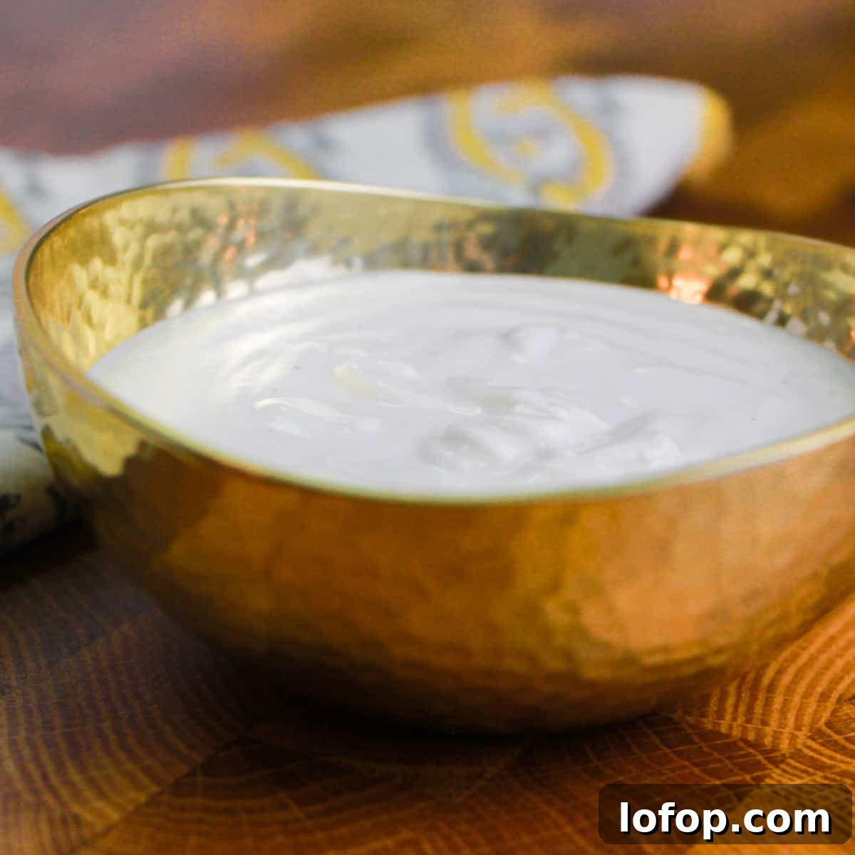 photo of a small brass bowl filled with cashew cream.