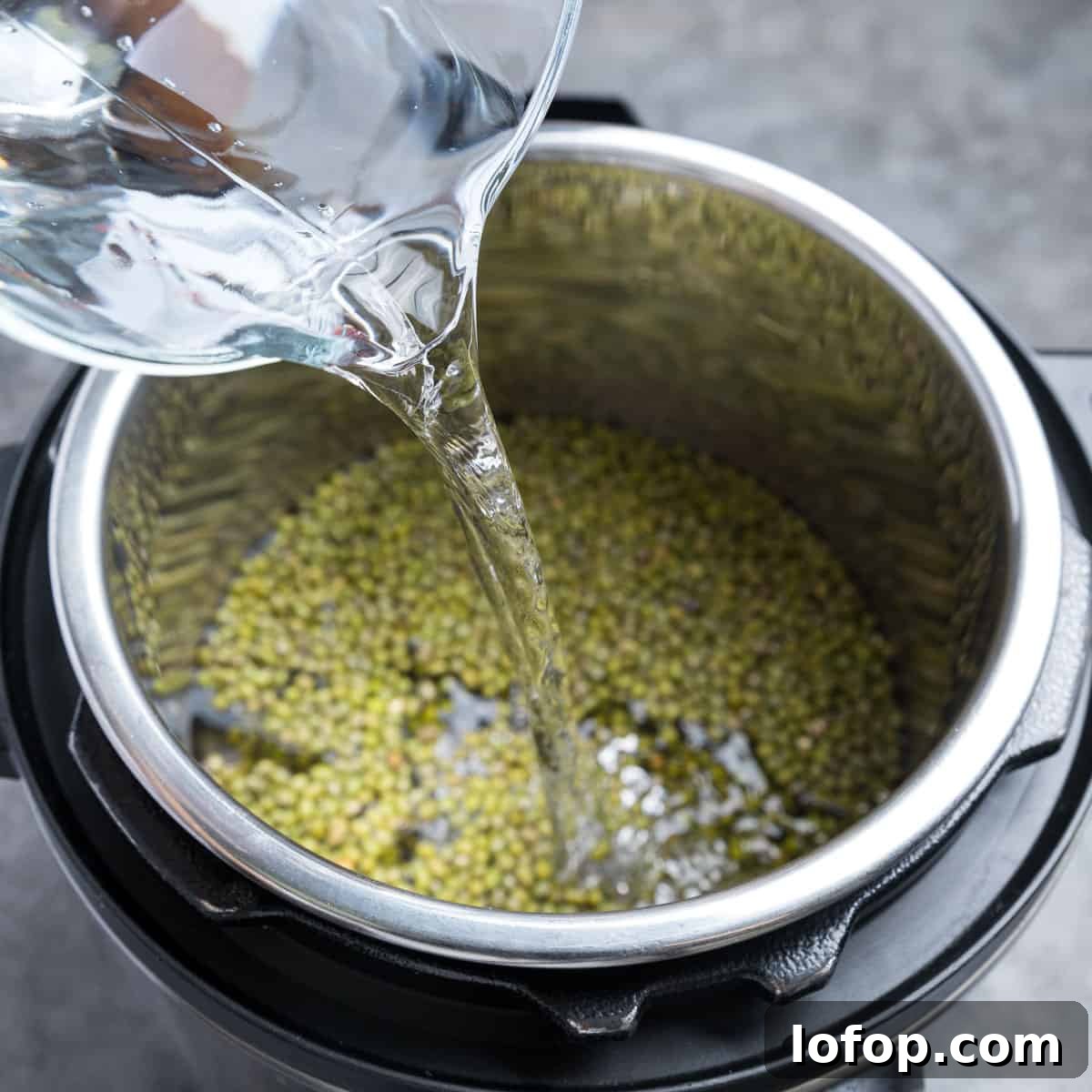 Perfect Instant Pot Mung Beans: Tender, Flavorful Every Time 7 Photo showing water being poured into the instant pot.