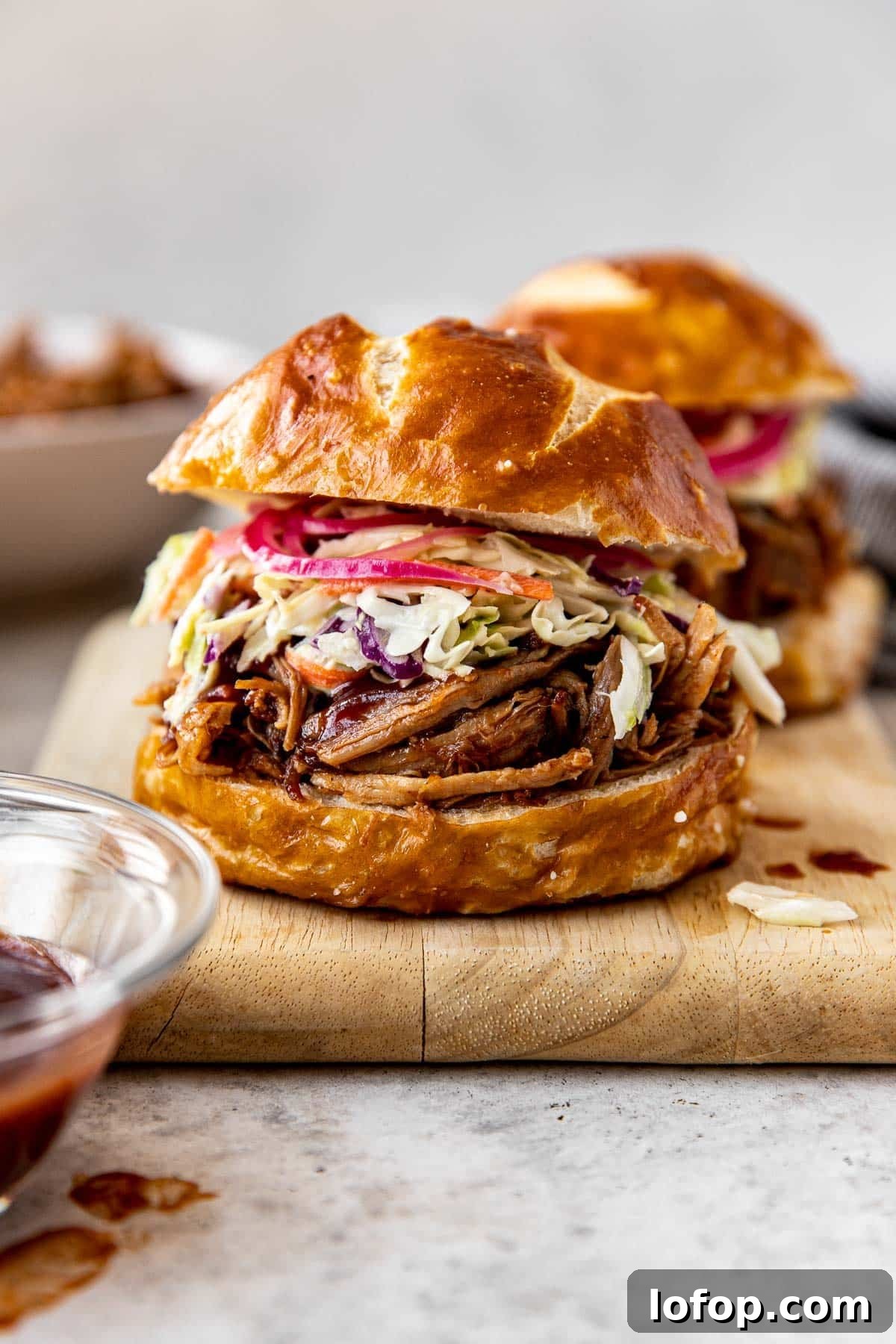 a pulled pork sandwich with slaw and pickled onions.