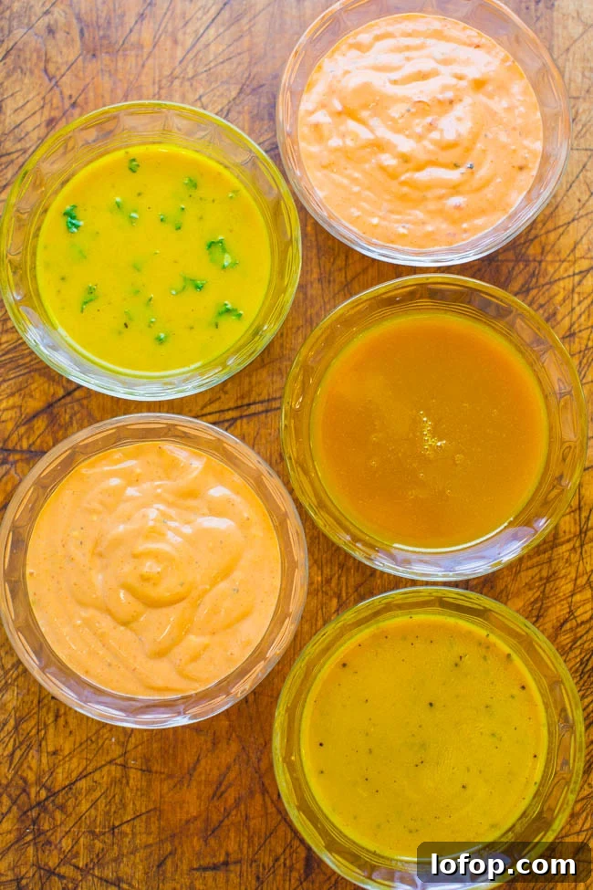 Assorted dressings or sauces in transparent bowls on a wooden surface.