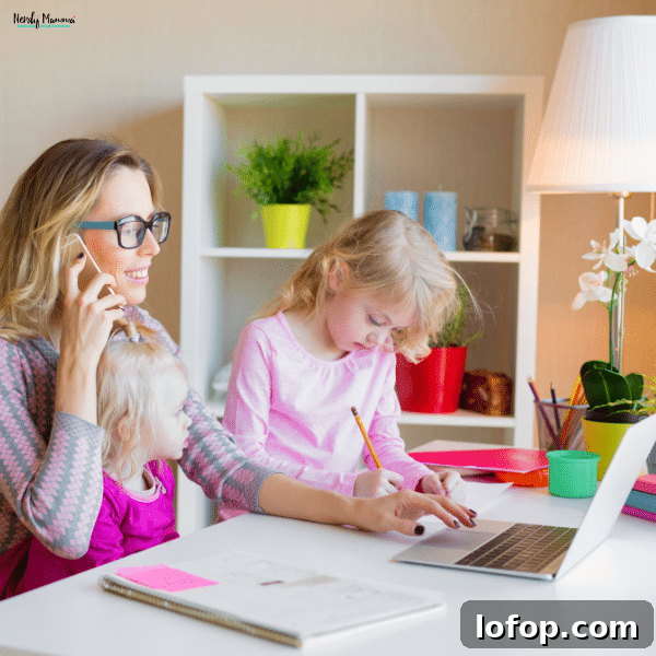 Mother multitasking at a desk with a laptop and phone while caring for her two young children, illustrating work-from-home jobs for moms.