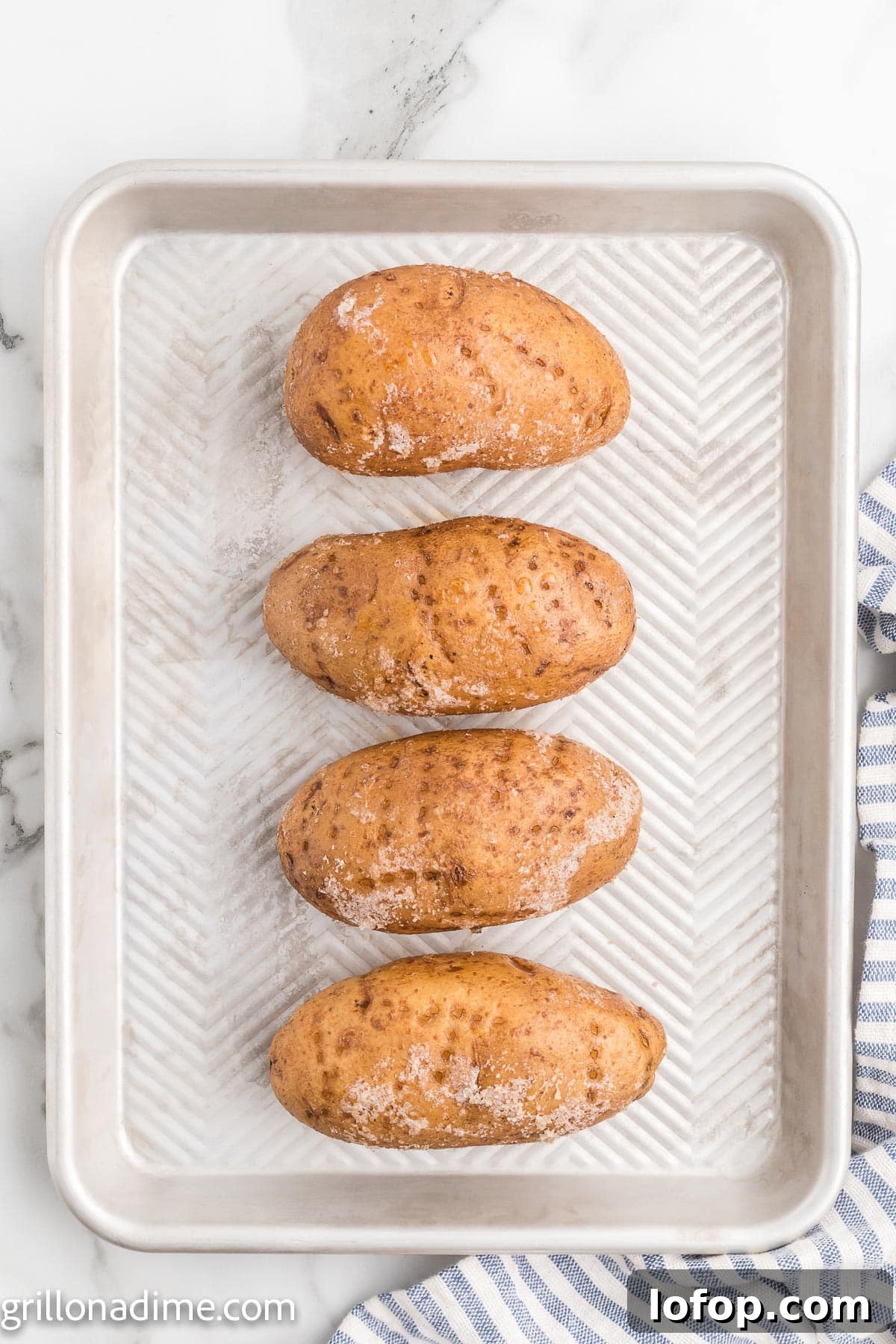 Smoked Baked Potatoes Recipe: Crispy Skins and Tender Centers 4 Baked Potatoes on a baking sheet