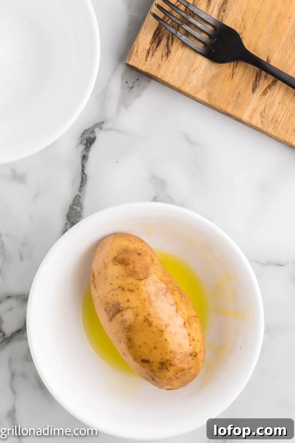 Smoked Baked Potatoes Recipe: Crispy Skins and Tender Centers 5 Bake potatoes being covered in a oil in a bowl