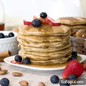 Fluffy Almond Flour Pancakes — Gluten-Free Recipe 9 A stack of fluffy almond flour pancakes with maple syrup on top.