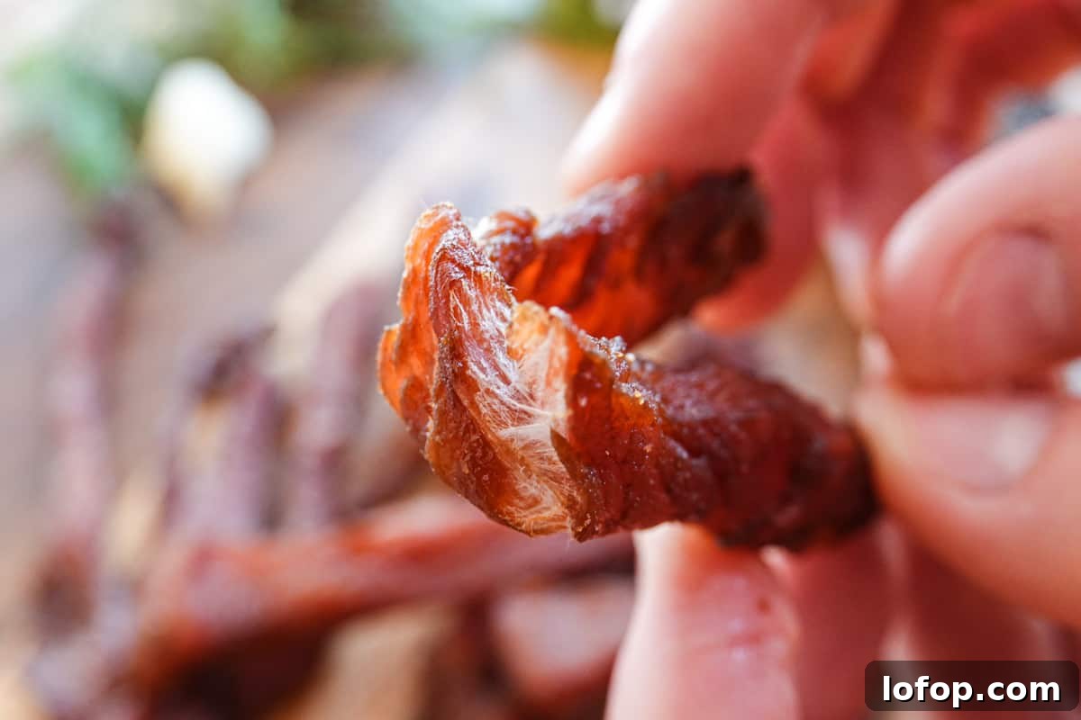 Homemade Turkey Jerky Recipe: Tender, Flavorful & Easy to Make 7 turkey jerky being bent showing it is finished drying