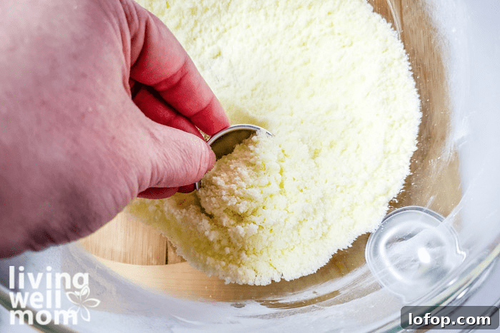 DIY Coconut Bath Bombs for Deep Hydration and Soft Skin 11 Coconut mixture being scooped into a mold.