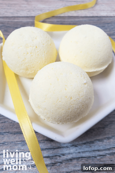 DIY Coconut Bath Bombs for Deep Hydration and Soft Skin 4 Three yellow DIY bath bombs on a white plate.