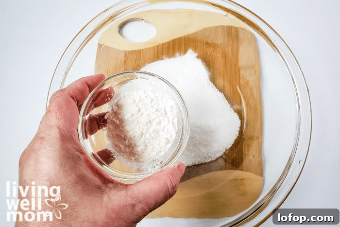 DIY Coconut Bath Bombs for Deep Hydration and Soft Skin 7 Corn starch being added into dry ingredients for homemade bath bombs.
