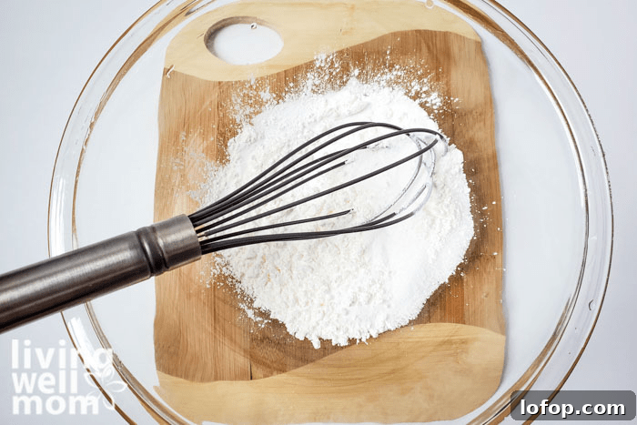 DIY Coconut Bath Bombs for Deep Hydration and Soft Skin 8 A whisk sitting in a bowl of DIY coconut bath bomb mixture.