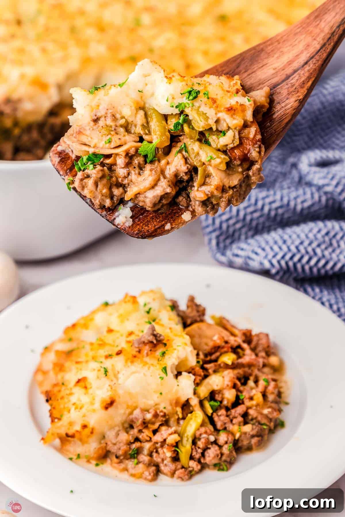 Hearty Salisbury Steak Casserole with Savory Brown Gravy 13 plate of salisbury steak casserole with a wood spoon