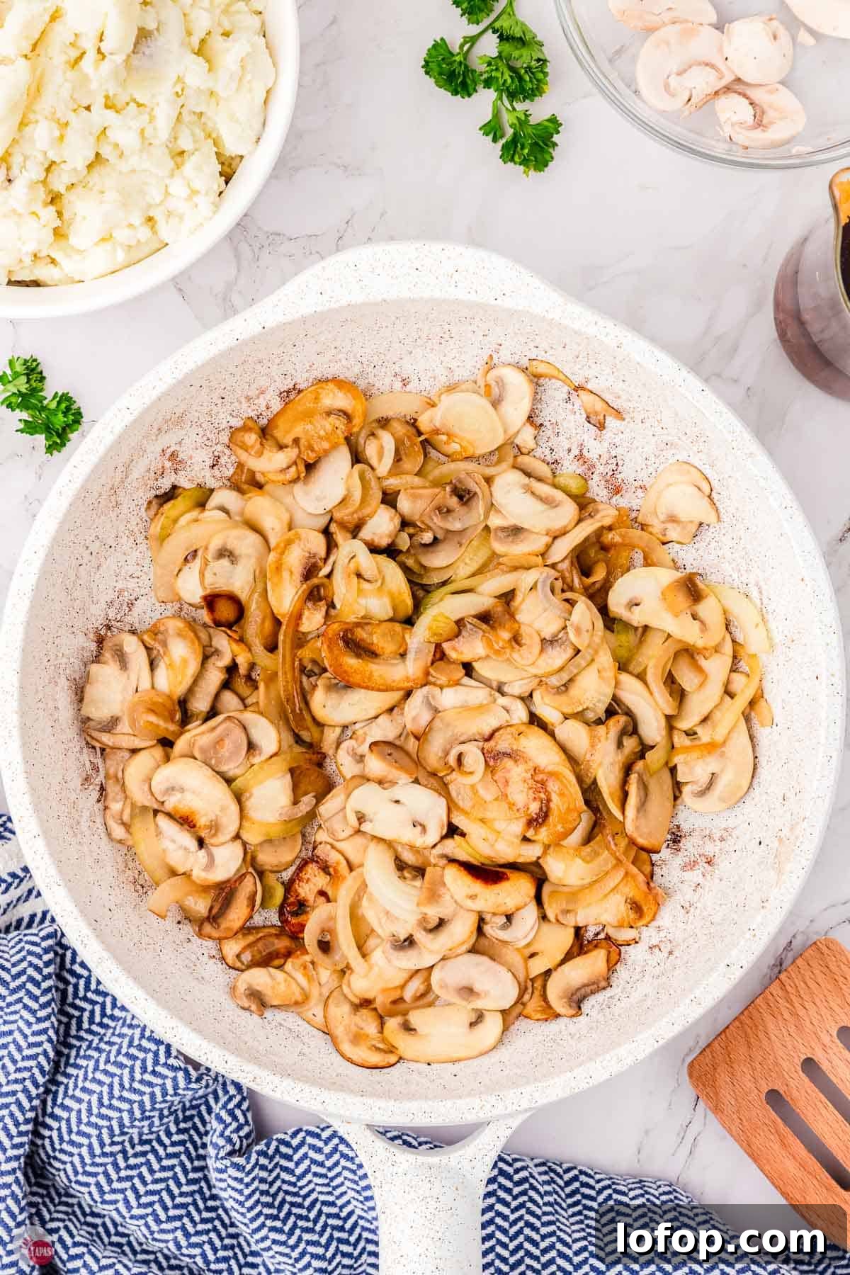 Hearty Salisbury Steak Casserole with Savory Brown Gravy 4 cooked mushrooms in a white skillet