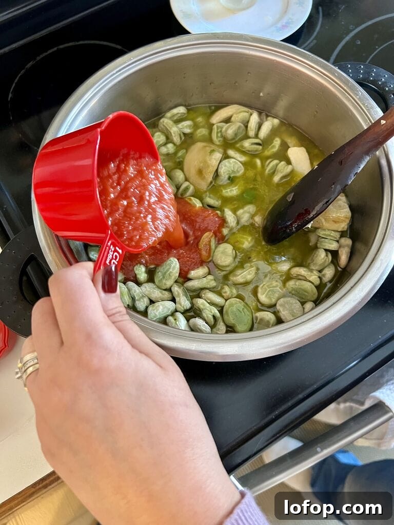 Adding tomato sauce to the pot.