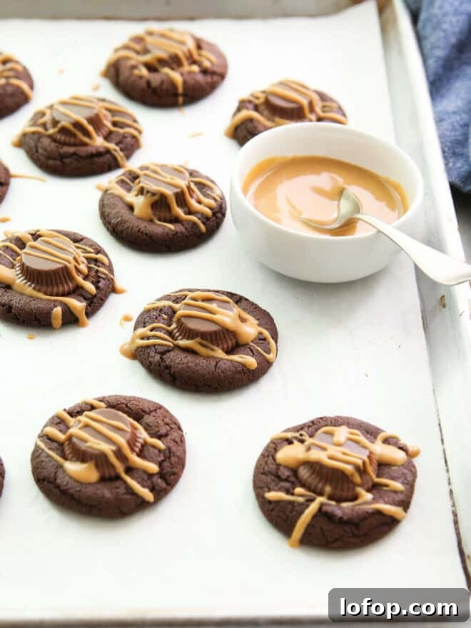 Irresistible Chocolate Peanut Butter Cup Cookie Recipe 8 chocolate peanut butter cup cookies with bowl of peanut butter for drizzling